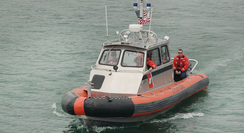  A coast guard boat motors across a body of water. 