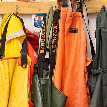  Fishing coveralls hang on hooks. 